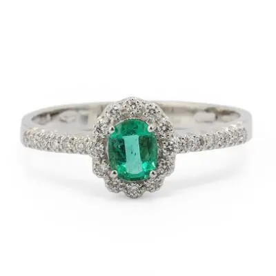 An emerald ring set with an emerald and numerous diamonds mounted