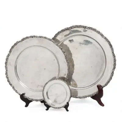 Peruvian silverware comprising two trays and a bottle coaster of sterling