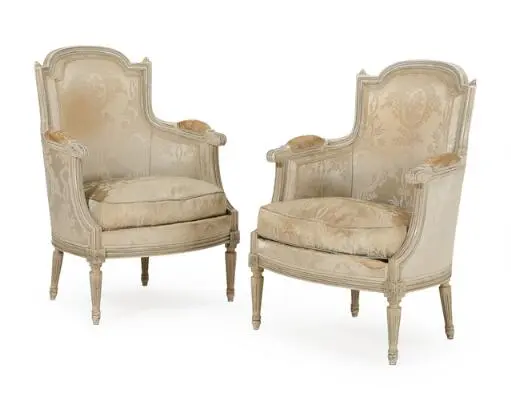 A pair of French Louis XVI style bergeres of carved and painted wood.