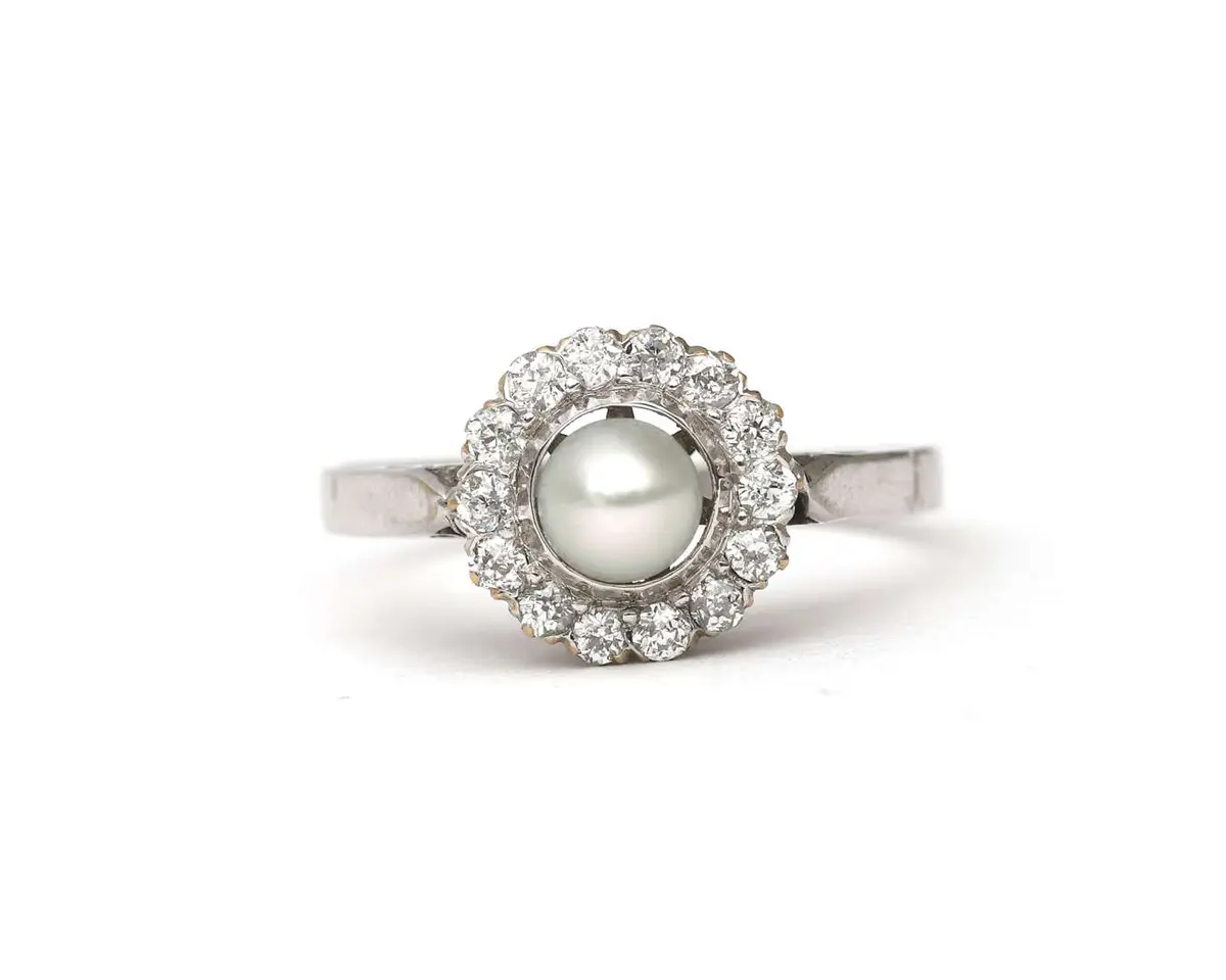 A 14k white gold ring set with a cultured pearl and a diamond