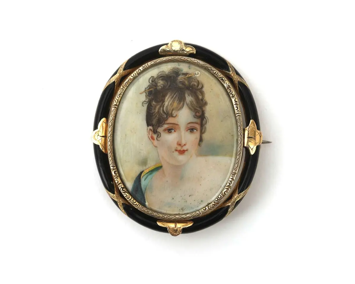 A 14k yellow gold brooch with a miniature