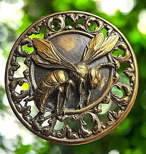 A COOL DIVISION ONE PIERCED BRASS ANIMAL BUTTON