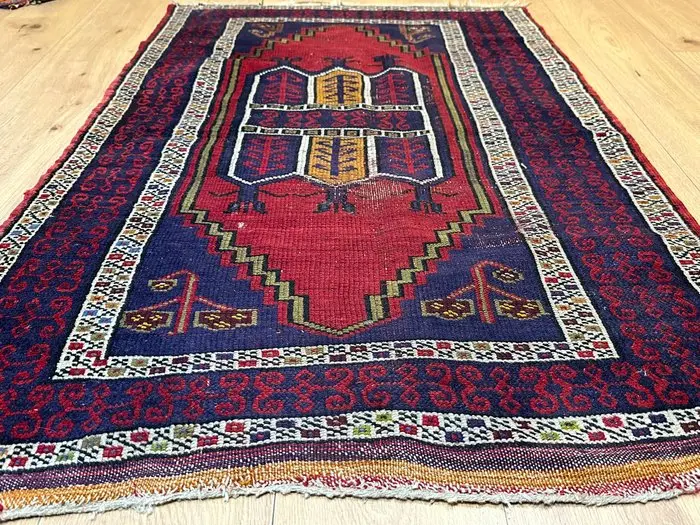 Antique Oriental rug with traditional tribal patterning...