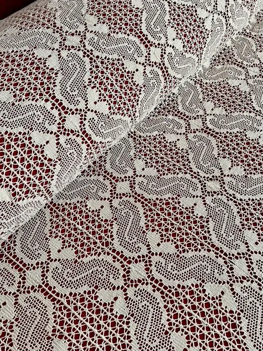 ** Antique cream-colored bobbin lace bedspread for double beds