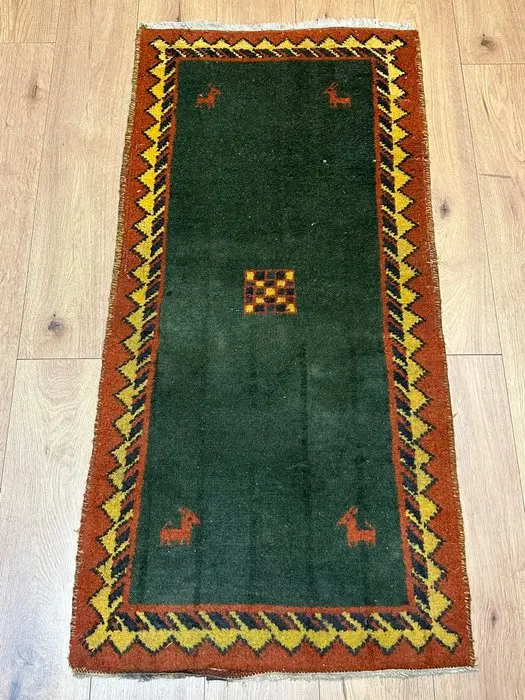 Beautiful Gabbeh runner with a deep green field and animal motifs