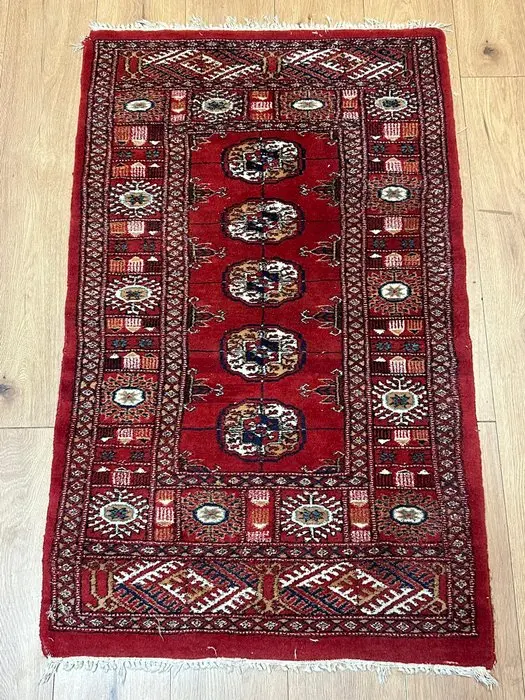 Fine antique Oriental rug in Bukhara style with characteristic gul medallions
