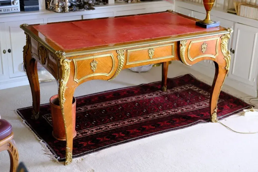 Veneered wood desk with a curly-grain inlay design, featuring three