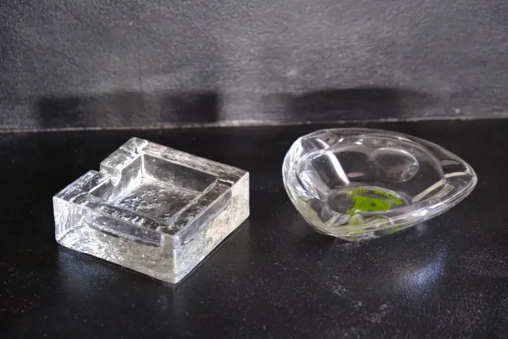 Two ashtrays, one made of frosted crystal, the other made of glass