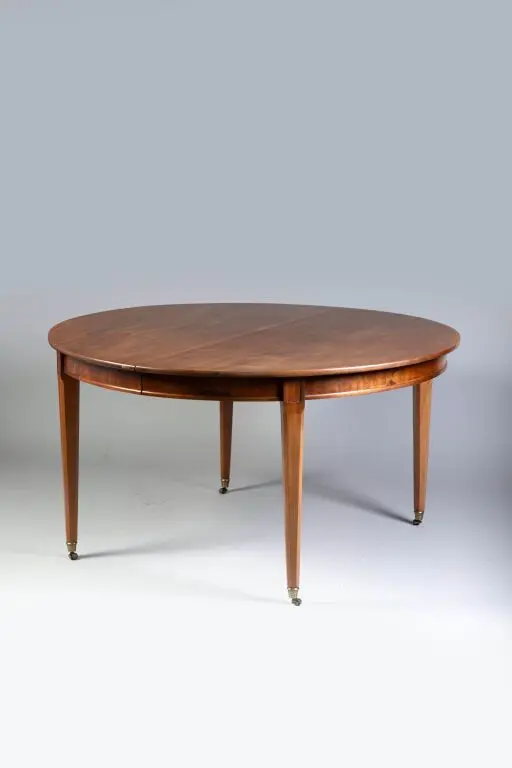 Oval mahogany dining table resting on beveled legs. Dated to the late