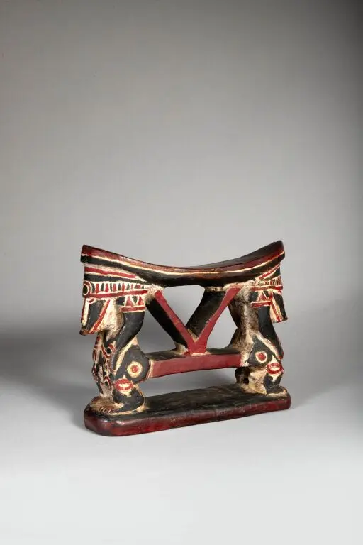 Neck rest featuring two opposing figures. Red and white polychrome