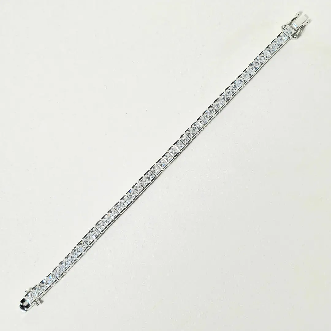 Pulsera riviere en plata rodiada con circonitas talla princesa.