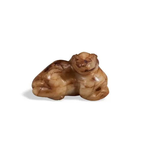 A YELLOW AND RUSSET JADE FIGURE OF A LION 18TH / 19TH CENTU...