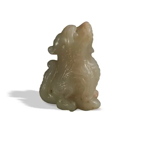 A MOTTLED CELADON JADE FIGURE OF A MYTHICAL BEAST QING DYNA...