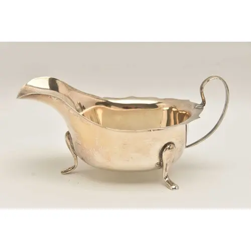 A GEORGE V SILVER SAUCE BOAT, polished form with wavy rim an...