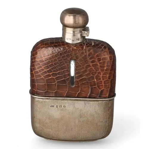 AN ART DECO SILVER MOUNTED GLASS AND CROCODILE SPIRITS FLASK...