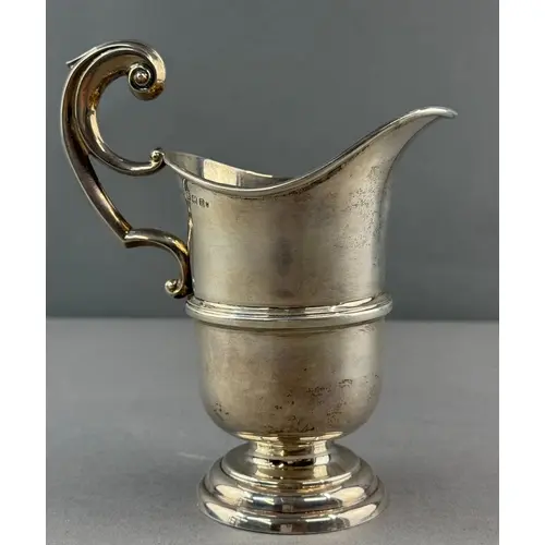 Silver: a cream jug of helmet form with bifurcated flying sc...