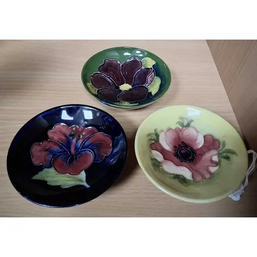 THREE SMALL MOORCROFT POTTERY DISHES, of shallow footed form...