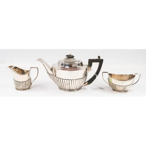 Silver: a three piece half gadrooned tea set, teapot and cre...