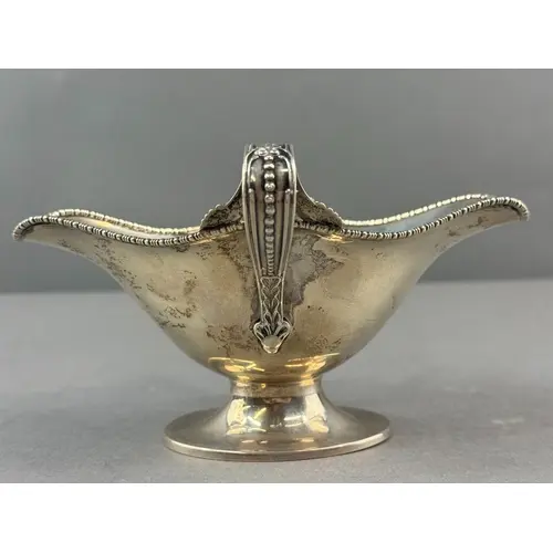Silver: an Edward VII double lipped pedestal sauce boat by B...