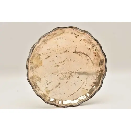 AN ELIZABETH II SILVER WAITER, circular form with a wavy gad...