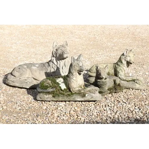 Four reconstituted stone figures of dogs, all modelled in re...
