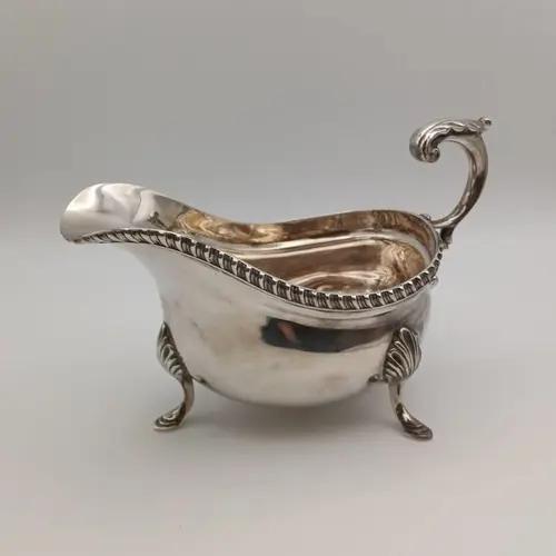 A SILVER SAUCE BOAT ON 3 FEET BY ISRAEL FREEMAN & SON LTD. L...