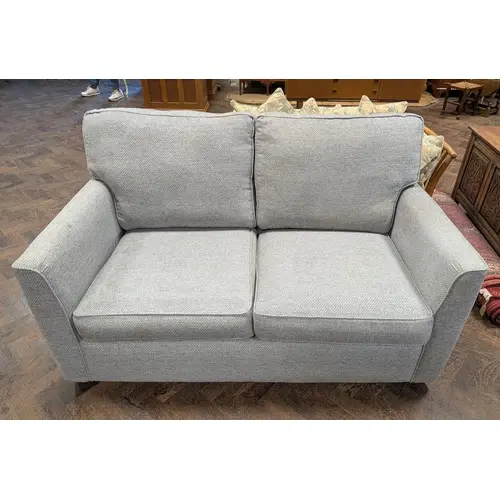 A modern two seater bed settee in grey covering with loose c...