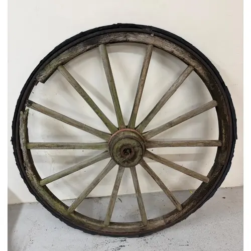 A wooden wagon wheel with metal rim band
