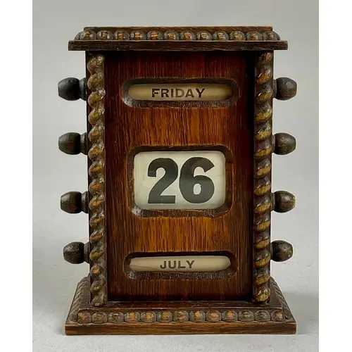 An early 20th century oak perpetual desk calendar, glazed ap...