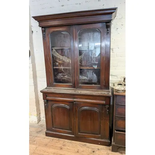 A Victorian style mahogany two door glazed bookcase standing...