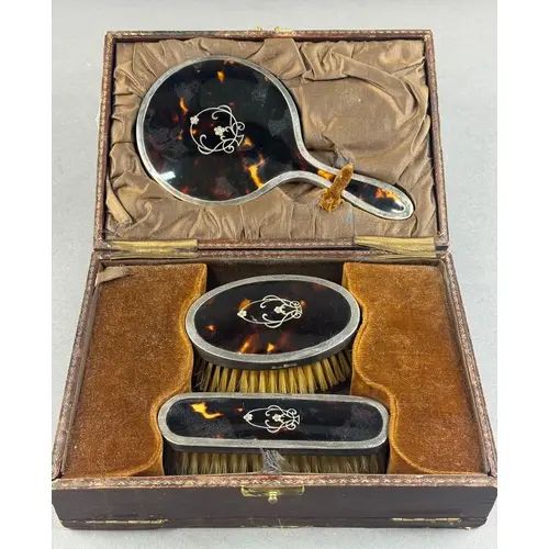 Silver: a silver mounted tortoiseshell dressing table set by...