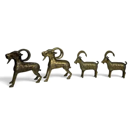FOUR ISLAMIC BRONZE RAMS One inlaid with silver. Largest 21c...