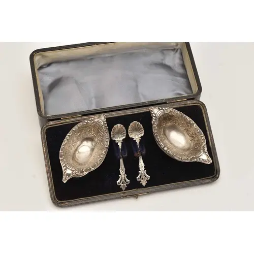 A CASED PAIR OF LATE VICTORIAN SILVER SALTS, each of an oval...