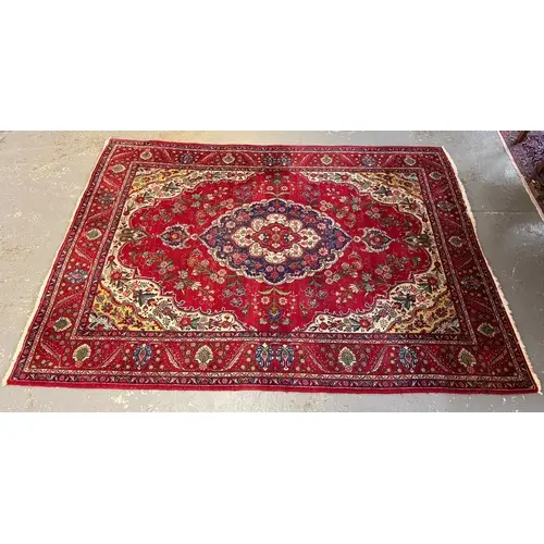 Large Persian style woollen carpet on a red ground with intr...