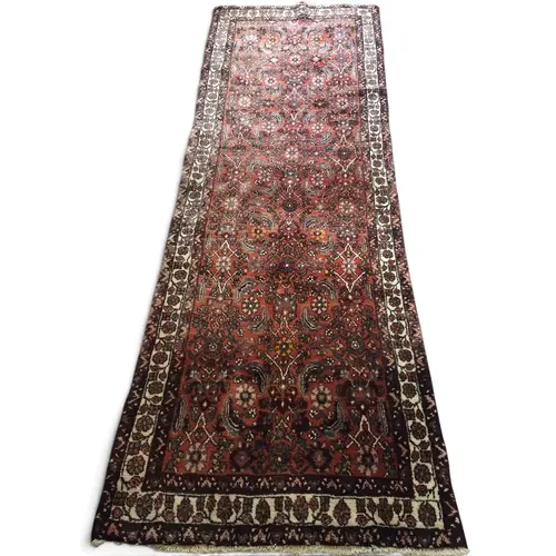 A rich red ground Persian Nahavand carpet, hand-woven with a...
