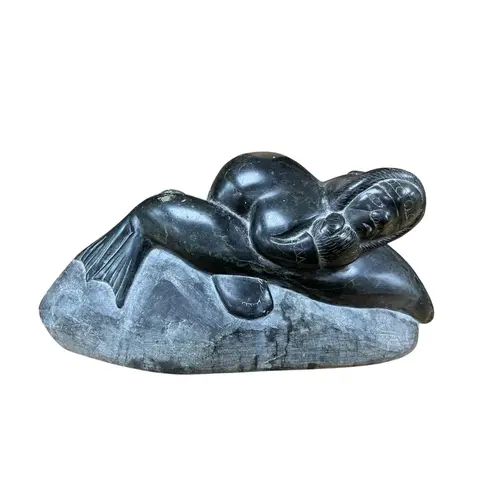 An Inuit carved stone group of a fisherman attacking a seal,...