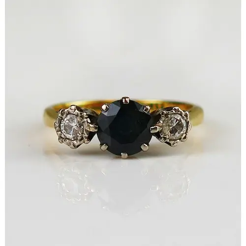 A sapphire and diamond three stone ring in an 18ct yellow go...