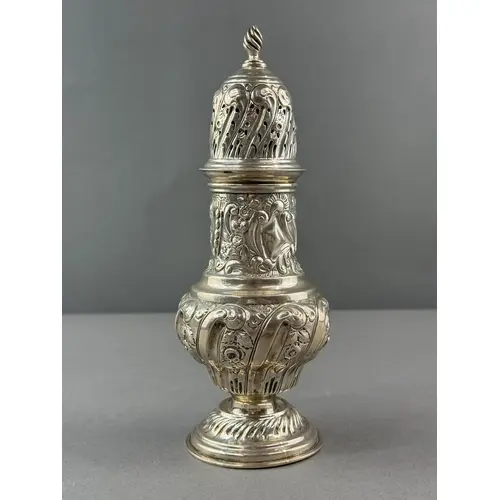 Silver: a baluster caster with leaf and flower repousse deco...