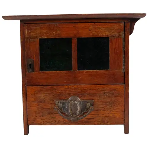 A small oak Art Nouveau smoker's cabinet, with green glazed...