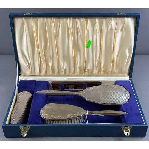 Silver: a four piece dressing table set by Broadway & Co...