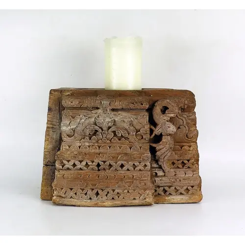 A Southeast Asian carved wooden candle holder, 30cm wide