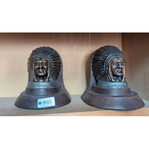 A pair of oak bookends inset with cast metal plaques modelle...