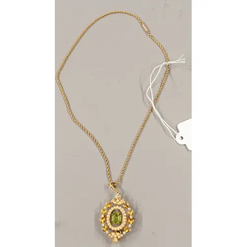 Jewellery: a yellow metal pendant brooch, set with a central...