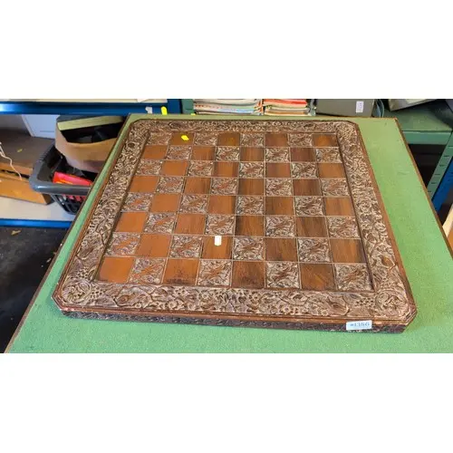 Carved wooden chessboard with alternating plain and dragon-d...