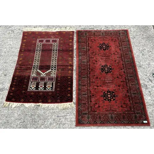 A hallway runner rug on deep red background and a tribal pra...