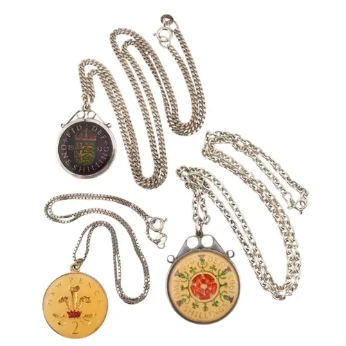 A collection of silver and enamel coin pendant necklaces. Th...