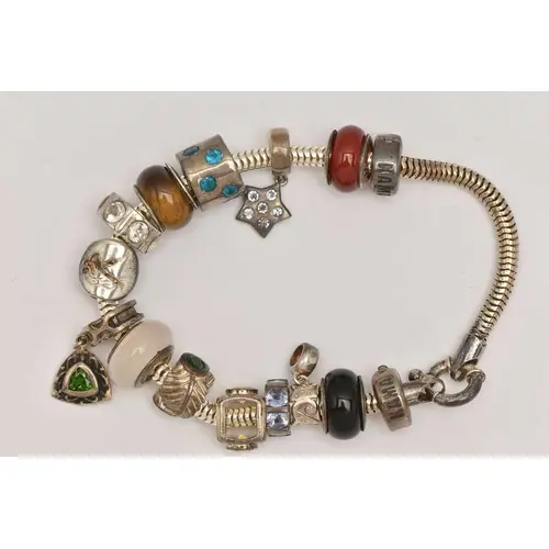 A SILVER CHARM BRACELET, snake bracelet fitted with a large ...