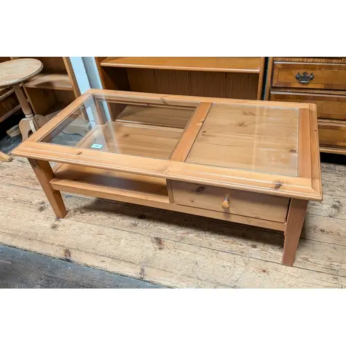 A modern pine storage style coffee table with inset glass to...