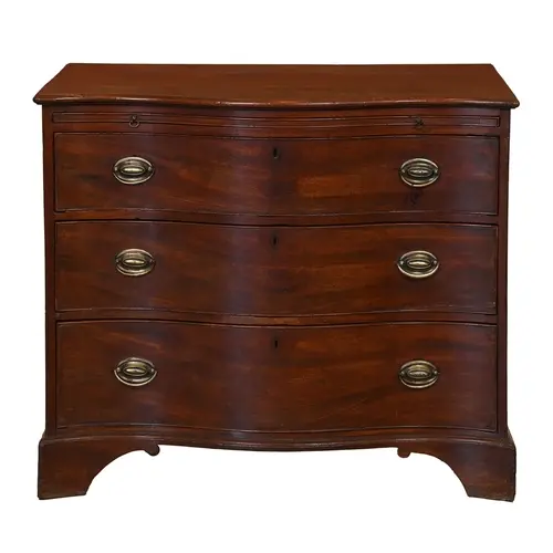 A George III serpentine mahogany chest of drawers, with cop-...