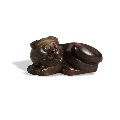 A SMALL RUSSET BROWN JADE FIGURE OF A FELINE MING DYNASTY (1...